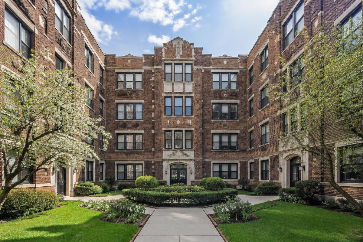 U-shaped vintage brick courtyard apartment building with a landscaped courtyard